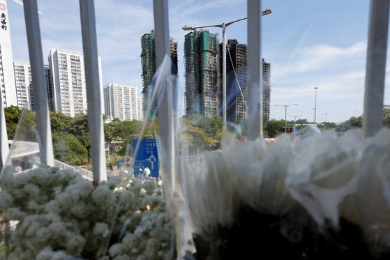 火災で大惨事が発生した香港大埔区の高層マンション群の近くに28日（現地時間）、犠牲者を哀悼する花が置かれている。 ［ロイター＝聯合ニュース］