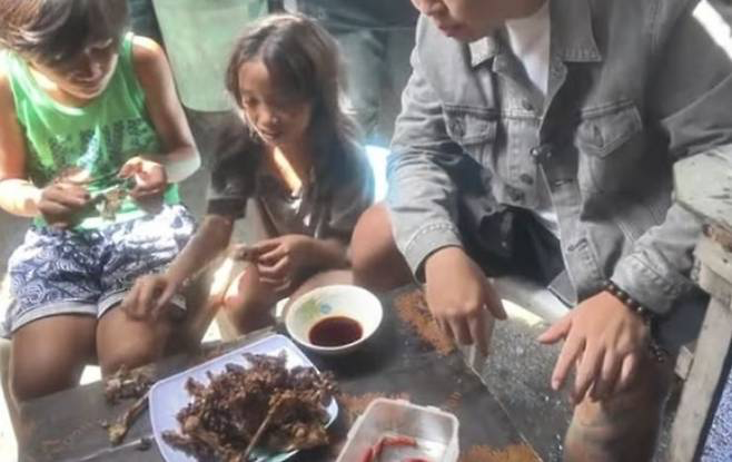  フィリピンの子どもとパグパグを食べる中国のインフルエンサー ［写真 sns］