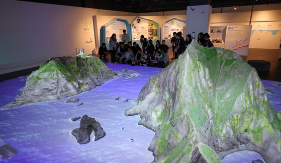   北東アジア歴史財団独島体験館開館式で説明を聞く学生たち。［写真 ニュース1］