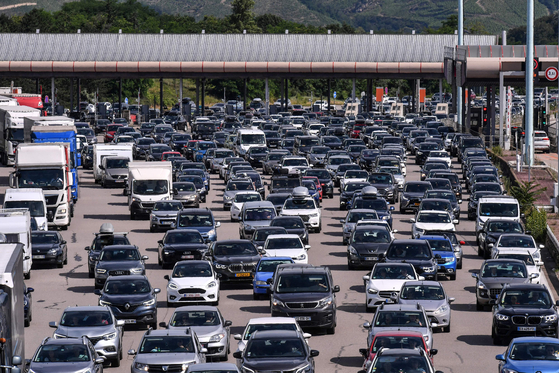  EUは15日、エンジン車販売を全面禁止しようとしていた方針を事実上撤回することにした。写真はフランスの高速道路料金所に並ぶ車。［写真 AFP＝聯合ニュース］