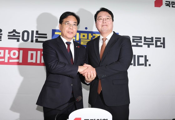 韓国野党「国民の力」の宋彦錫（ソン・オンソク）院内代表（左）と「改革新党」のチョン・ハラム院内代表が17日、国会で「統一教会特検」関連の会合に先立ち握手をしている。この場で両院内代表は、統一教会による政界への違法政治資金疑惑を糾明するための特別検察法案の発議に共感を示したが、特検の推薦権と捜査範囲をめぐっては立場の違いを見せた。イム・ヒョンドン記者