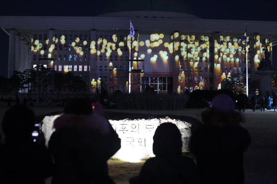 非常戒厳から1年を迎えた3日、ソウルの国会議事堂に戒厳解除当時の記憶を再確認するメディアファサードが設置された。［写真 ニュース1］