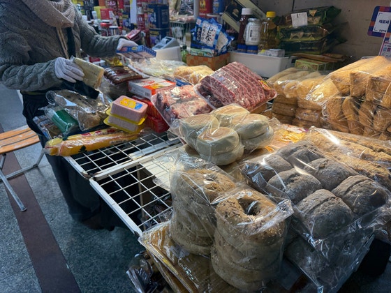 22日、ソウル南大門（ナムデムン）市場で、輸入チーズやパンなどを整理している商人のアンさん（73）。ナム・スヒョン記者
