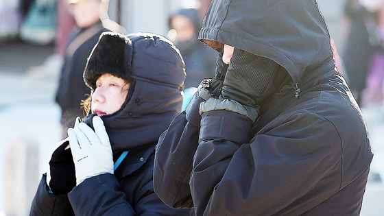 ソウルと京畿道（キョンギド）に寒波注意報が出された25日、ソウル鍾路区（チョンノグ）の景福宮（キョンボックン）を訪れた外国人観光客が、厳しい寒さの中、マフラーなどの防寒用品を身に着けて移動している。［ニュース1］