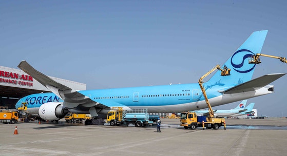 仁川市中区（インチョンシ・チュング）の仁川国際空港にある大韓航空の格納庫で、社員たちが春を迎えて航空機の胴体を洗浄している。［共同取材団］