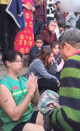  抗議するガンジス川の地元住民と合掌して謝罪する観光客。［写真 X（旧ツイッター）キャプチャー］ 