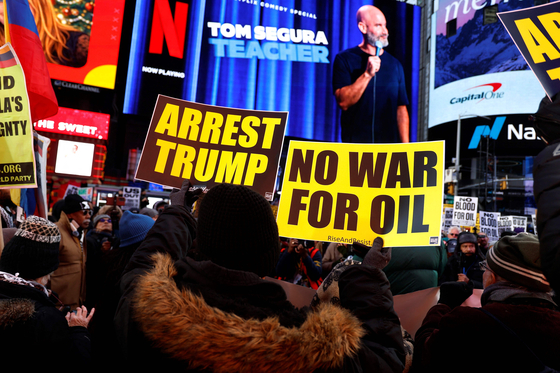 3日、ニューヨークのタイムズスクエアでベネズエラに対する米国の軍事行動に反対するデモが開かれた。ある参加者が「石油のための戦争はいらない」というプラカードを掲げた。［写真 AFP＝聯合ニュース］