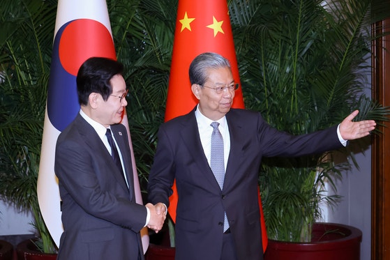 韓国の李在明（イ・ジェミョン）大統領が6日、中国・北京の人民大会堂で、趙楽際・全国人民代表大会（全人代）常務委員長の出迎えを受けている。［青瓦台写真記者団］