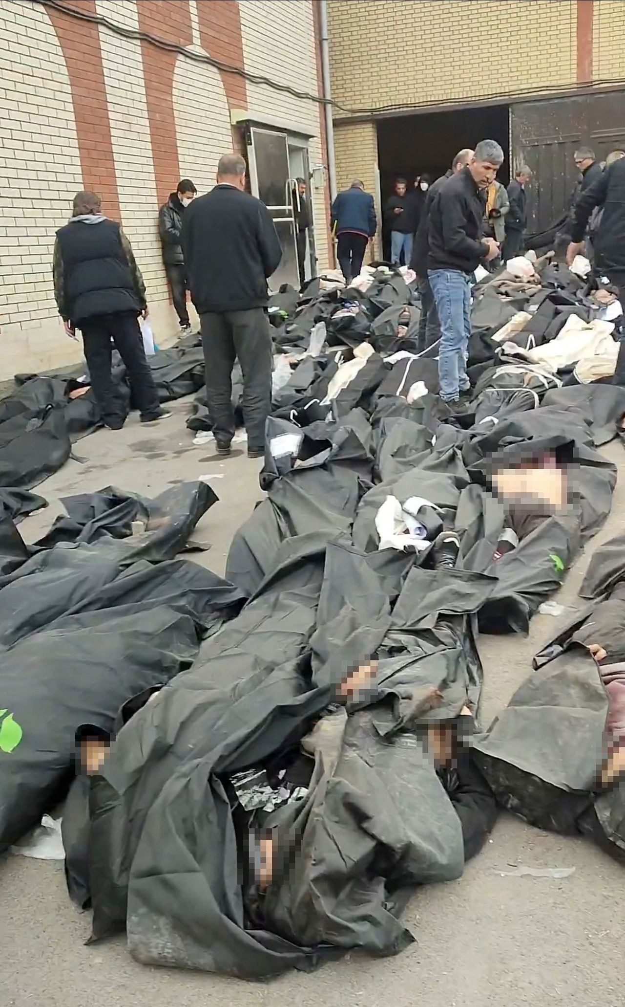 イラン・テヘランの法医学センター付近で反政府デモ中に死亡した市民の遺体が並べられている。［写真 ロイター＝聯合ニュース］