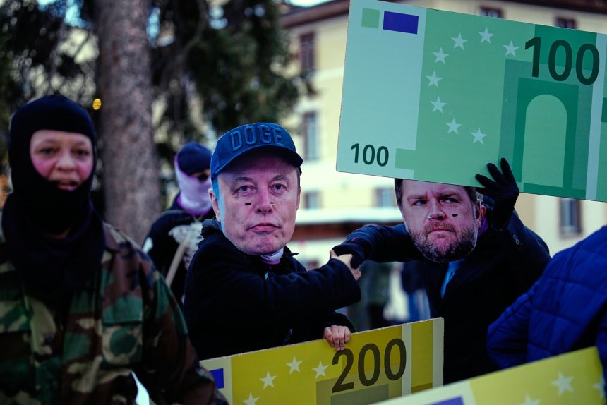 18日、スイスのダボスでテスラのイーロン・マスクCEO（中央）とバンス米副大統領（右）の仮面をかぶった人たちがダボス会議反対デモをしている。［写真 AP＝聯合ニュース］