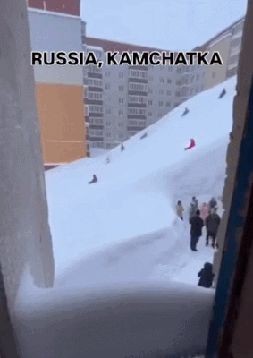   巨大なスキー場のように変わったアパートで雪そりを楽しむロシアの子どもたち。［SNS　キャプチャー］