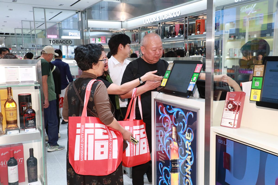 ショッピングをしている外国人観光客。写真＝新世界免税店