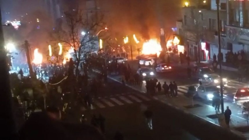 14日（現地時間）、イラン・テヘランのサアダト・アーバード広場で、デモの最中に車両が炎上している様子。［AFP＝聯合ニュース］