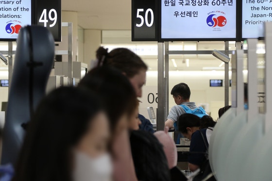 韓日両政府が国交正常化60周年を迎え、昨年6月の1カ月間、相手国国民専用の入国審査レーンを運用することで合意した中、制度初日となった同月1日、東京・羽田空港で韓国人観光客が「韓国人優先レーン」を通って入国手続きを行っている。聯合ニュース