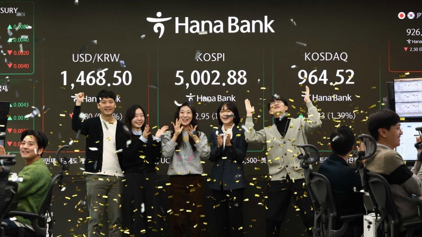 韓国総合株価指数（KOSPI）が史上初めて取引時間中に5000ポイントを突破した22日、ハナ銀行のディーラーたちが祝賀行事を行っている。ニュース1