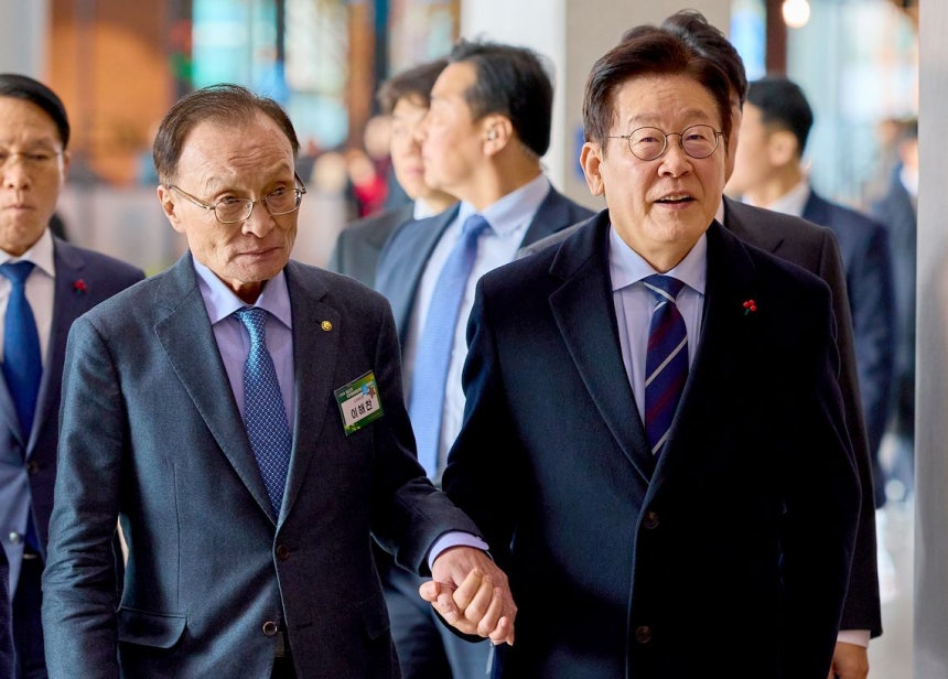 昨年12月2日、第22期民主平和統一諮問会議の発足式が開かれた京畿道高陽市（コヤンシ）の韓国国際展示場（KINTEX）で、李在明（イ・ジェミョン）大統領が李海瓚（イ・ヘチャン）首席副委員長の手を握って行事場所に移動している。 ［写真 大統領室］