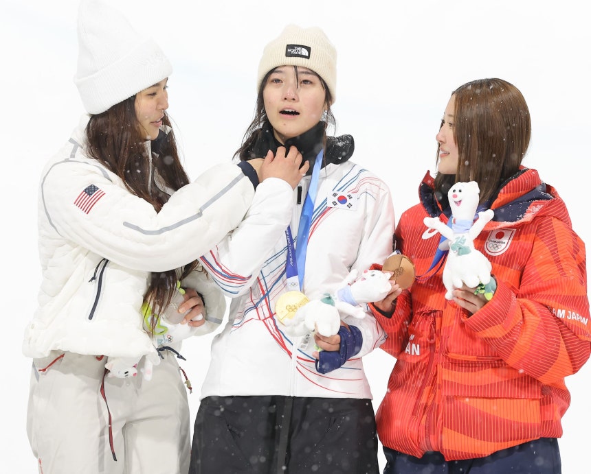12日（現地時間）、イタリア・リヴィーニョのスノーパークで行われた2026年ミラノ・コルティナダンペッツォ冬季オリンピック（五輪）のスノーボード女子ハーフパイプ決勝で銀メダルを獲得した米国のクロエ・キムが、金メダルを獲得したチェ・ガオンの身だしなみを整えてやっている。聯合ニュース