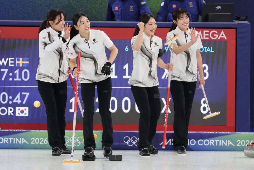 韓国女子カーリング代表のキム・ウンジ、キム・ミンジ、キム・スジ、ソル・イェウン（左から）が18日、世界最強のスウェーデンを7エンドで下し、4強入りへ望みをつないだ後、リザーブのソル・イェジに向かって手を振り喜んでいる。［聯合ニュース］