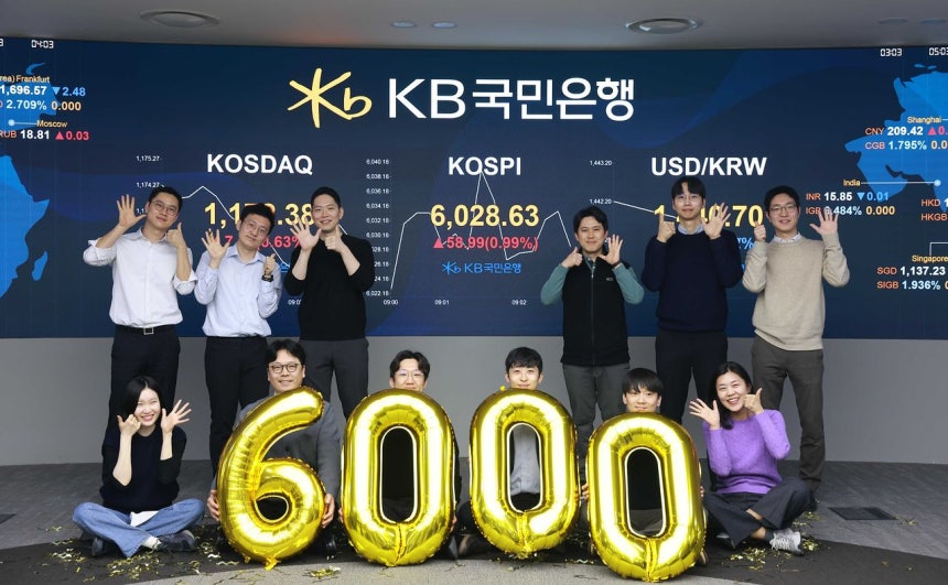 KOSPI（韓国総合株価指数）が取引開始と同時に6000を突破した25日午前、ソウル永登浦区（ヨンドンポク）KB国民銀行ディーリングルームで職員が祝っている。 ［写真 国民銀行］