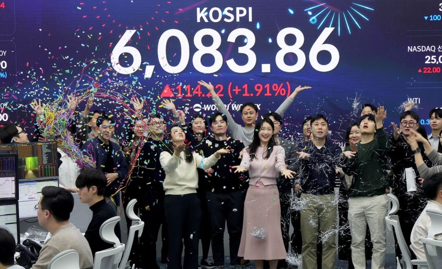  KOSPIが史上初めて6000ポイントを突破し6083．86で取引を終えた25日、ソウルのウリィ銀行本店ディーリングルームで従業員が歓呼している。チャン・ジニョン記者