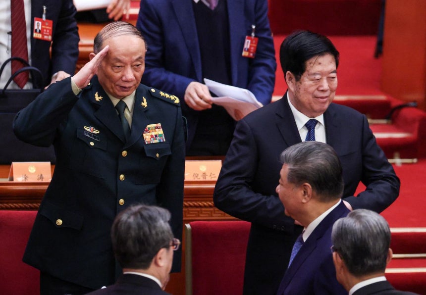 4日、中国の人民大会堂で開かれた全国政治協商会議の開幕式が終わった後、張昇民・中央軍事委員会副主席（左）が習近平国家主席に挙手敬礼をしている。この日、政治局員3人が欠席した。ロイター＝聯合ニュース