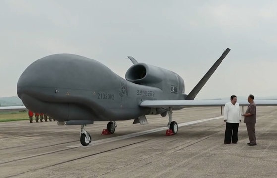 北朝鮮の金正恩国務委員長が2024年2月に当時の李炳哲党中央軍事委員会副委員長と米国の高高度無人偵察機グローバルホークと似た「セッピョル4」の前で対話している。［写真 朝鮮中央通信＝聯合ニュース］