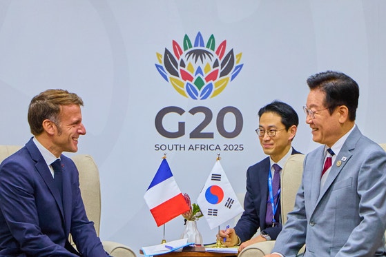 韓国の李在明（イ・ジェミョン）大統領とエマニュエル・マクロン仏大統領が昨年11月22日（現地時間）、南アフリカ共和国ヨハネスブルクのエキスポセンターの二者会談会場で行われた韓仏首脳会談で握手をしている。［写真 李在明大統領 SNS］ 