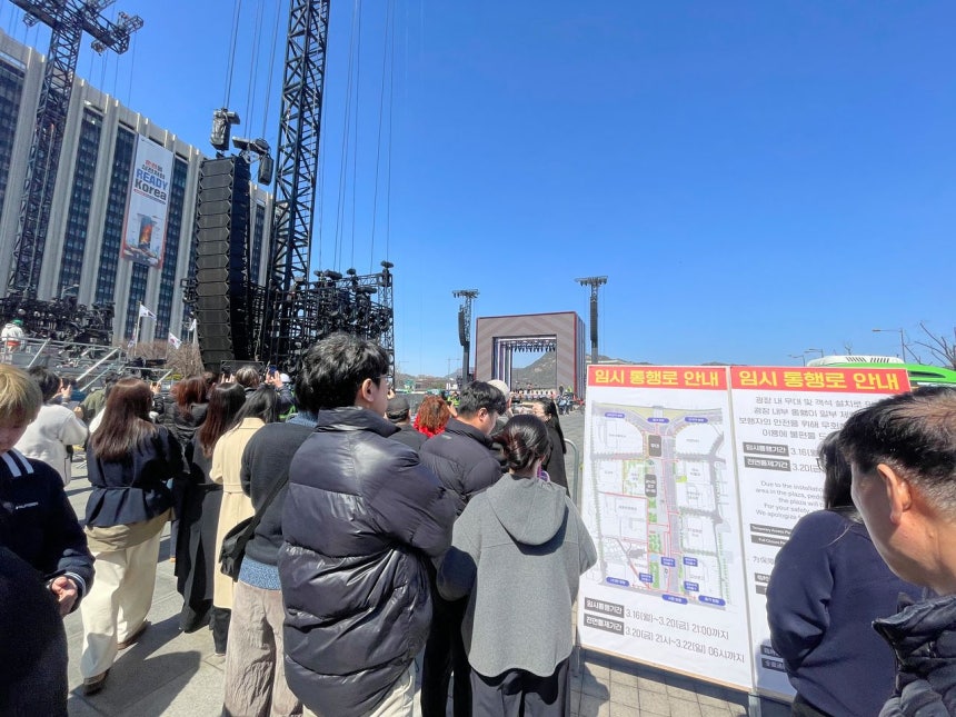 19日午後12時ごろ、光化門（クァンファムン）広場で21日に開催されるBTS（防弾少年団）のカムバック公演の準備現場を見守る市民。キム・イェジョン記者