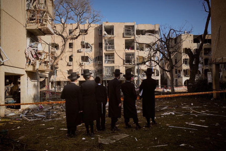 22日（現地時間）、イスラエル・アラドで市民がイランのミサイル攻撃で被害を受けた住宅を見つめている。AP＝聯合ニュース