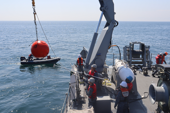 昨年4月11日に浦項東方海域で韓米合同機雷戦訓練に参加した掃海艦が機雷除去装備で切断した訓練用繋留機雷回収に向け艦尾の甲板クレーンを利用して機雷を引き上げている。［写真 韓国海軍］