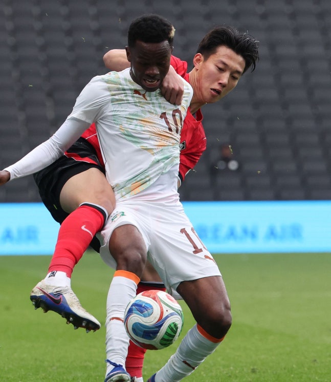 李韓汎（イ・ハンボム）がシモン・アディングラをボールを奪おうとしている。韓国サッカーはコートジボワールを相手にイエローカードを1枚も受けなかった。闘争心が不足した「ソンビサッカー（＝行儀が良いサッカー）」という批判も出てきた。 ［聯合ニュース］