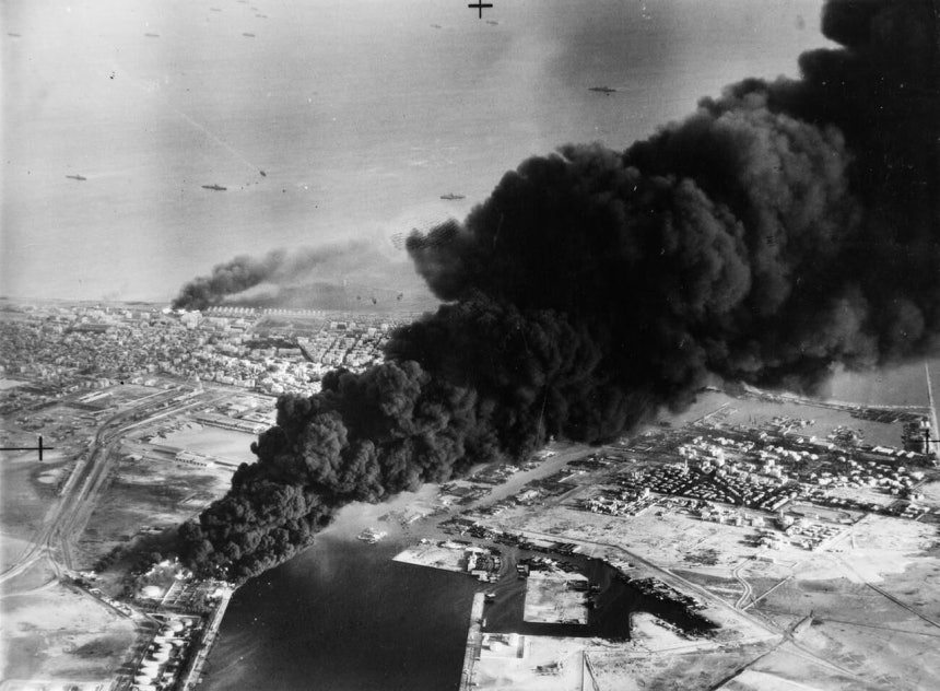 1956年11月5日、英国軍とフランス軍の攻撃により、エジプト・スエズ運河のポートサイド付近にある石油施設が煙に包まれている。［写真 ウィキペディア］