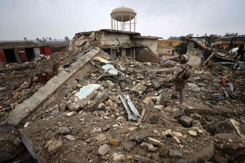 イラク軍が先月26日、バグダッドのハバニヤ軍基地内で空爆により破壊された保健所の現場を確認している。［AFP＝聯合ニュース］