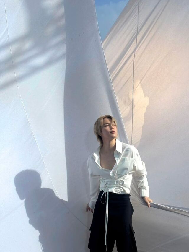   船上の白い帆を背景に幻想的な雰囲気を見せるBTSジミン。［SNS キャプチャー］