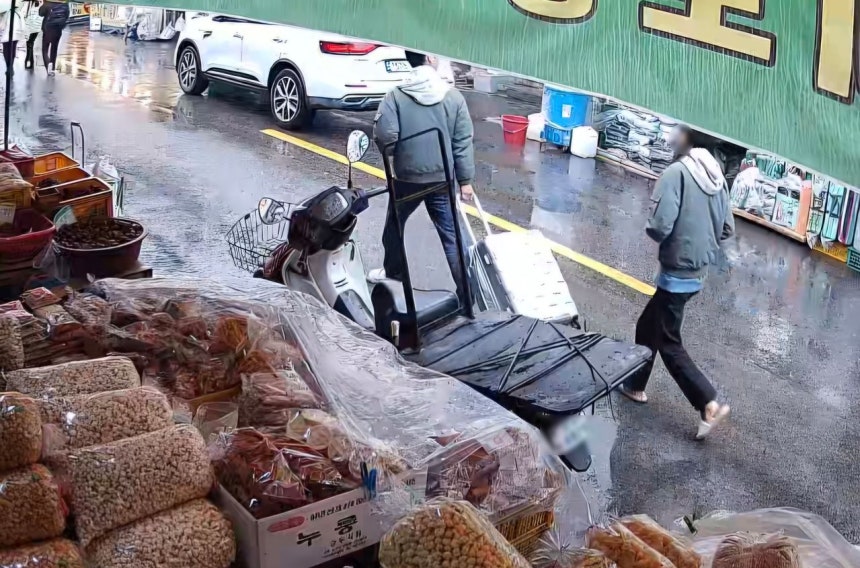  母親の遺体が入ったキャリーケースを転がしている20代の娘夫婦。聯合ニュース