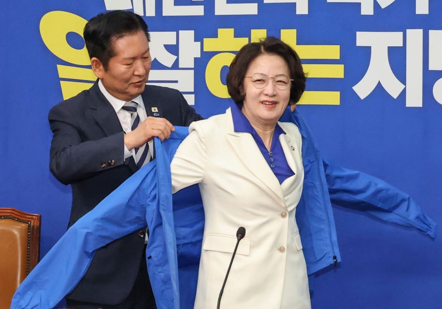 13日、国会で最高委員会を前に開かれた秋美愛（チュ・ミエ）京畿道知事候補の歓迎式で、共に民主党の鄭清来（チョン・チョンレ）代表が秋候補に選挙用ジャンパーを着せている。聯合ニュース