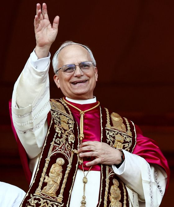 新しい教皇に選出された後、バチカンのサン・ピエトロ大聖堂のバルコニーで手を振っているレオ14世。ロイター＝聯合ニュース