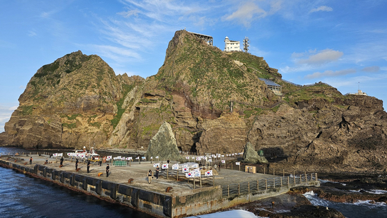 独島（ドクト、日本名・竹島）を訪れて太極旗を手に島周辺を巡っている観光客。／テジョ海運＝ニュース1