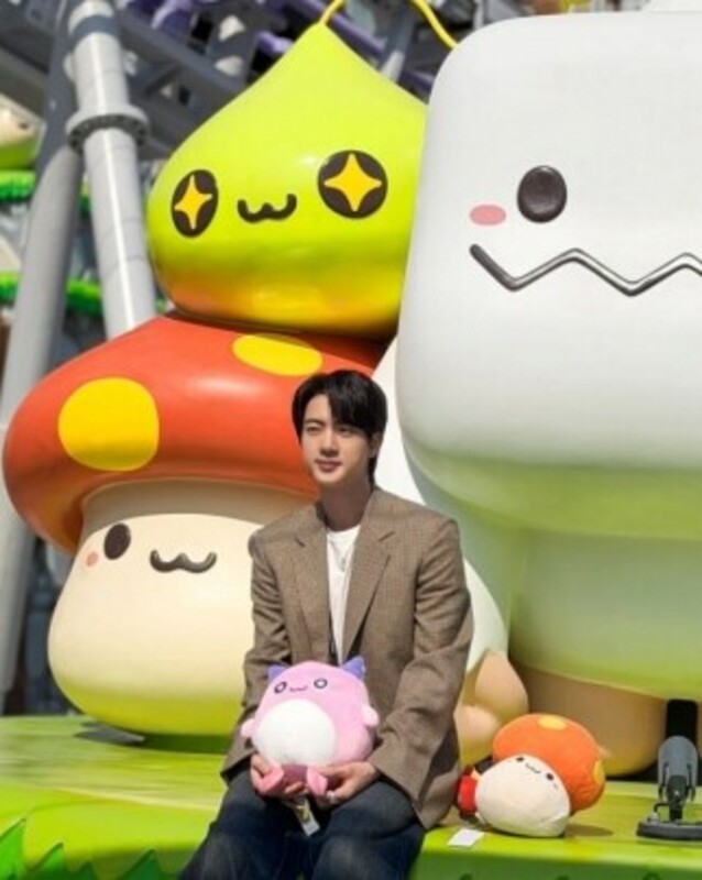 メイプルアイランドでピンクビーンの人形を抱いているBTS（防弾少年団）のジン。［SNS キャプチャー］