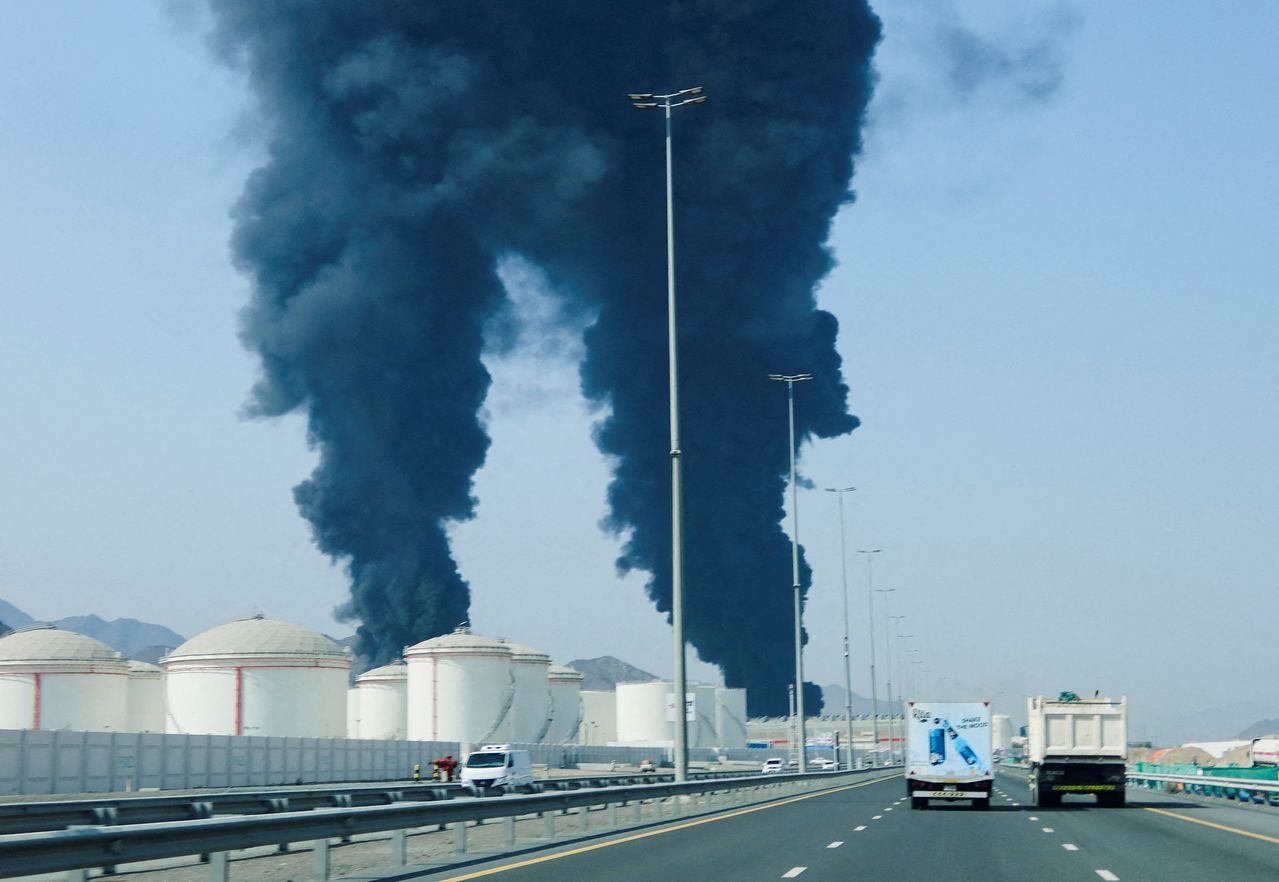 ホルムズ海峡を迂回する原油輸出拠点であるアラブ首長国連邦（UAE）フジャイラの石油産業地帯で、3月14日、ドローン迎撃による残骸で発生した火災の煙が立ち上っている。［ロイター＝聯合ニュース］