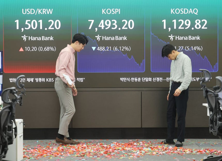 15日、KOSPI（韓国総合株価指数）が初めて8000ポイントを突破したが、その後に急落した。この日、ソウルハナ銀行ディーリングルームで職員が最高額記念の紙吹雪を片づけている。 ［聯合ニュース］
