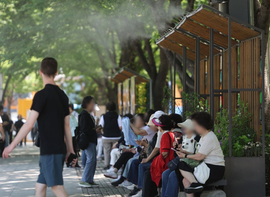  ソウルの昼の気温が31度まで上がるなど韓国各地で夏のような暑さとなった14日、ソウルの森で市民が暑さをしのいでいる。［写真 聯合ニュース］