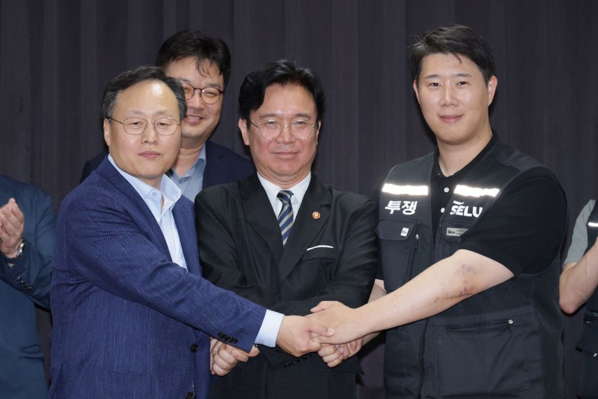 サムスン電子側代表交渉委員であるヨ・ミョングDSピープルチーム長（前列左）とサムスングループ超企業労働組合サムスン電子支部のチェ・スンホ委員長が20日、労組ストを1時間後に控え暫定合意案に署名した。前列中央は雇用労働部の金栄訓長官．キム・ソンリョン記者