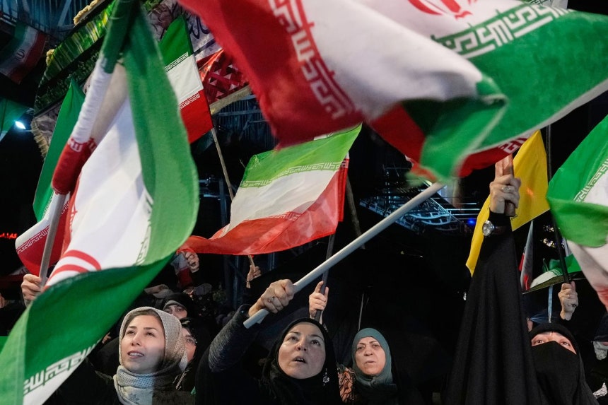 イラン・テヘラン中心街の広場で19日（現地時間）、政府側のデモ隊が国旗を振って集会を行っている。［AP＝聯合ニュース］
