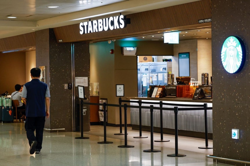 24日、仁川（インチョン）国際空港内のスターバックス店舗の前を市民が通り過ぎている。スターバックスコリアの5・18民主化運動記念日「タンクデー」マーケティング論争から始まった不買運動が、セウォル号惨事追悼日の「サイレン」論争まで重なり拡散している中、新世界グループの鄭溶鎮（チョン・ヨンジン）会長は、前SCKカンパニーのソン・ジョンヒョン代表とともに、5・18民主化運動等に関する特別法違反、侮辱および名誉毀損などの容疑でソウル警察庁に告発された状態だ。ニュース1