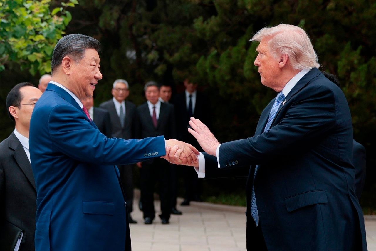 15日、中国・北京の中南海で、首脳会談を終えて会場を離れようとする直前に握手するトランプ米国大統領（右）と習近平中国国家主席（左）。AP＝聯合ニュース
