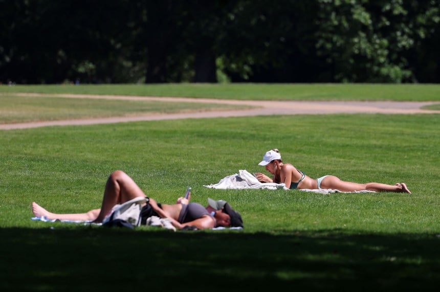 25日（現地時間）、英国ロンドンの公園で市民らが日光浴を楽しんでいる。英国ではこの日、気温が35度まで上昇し、5月としては観測史上最高の暑さになると予想された。［EPA＝聯合ニュース］