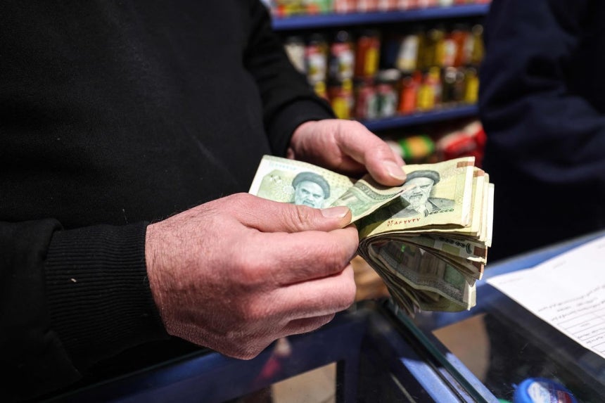 イランのテヘランの商店で商人がイランの通貨であるリヤルを数えている。［写真 AFP＝聯合ニュース］