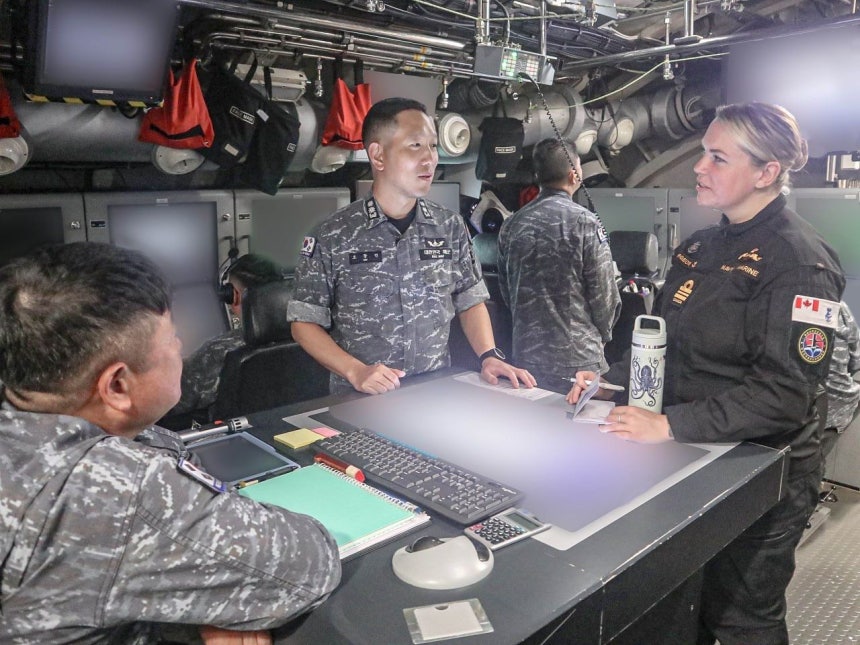 韓国潜水艦「安昌浩」でカナダ海軍将校（右）が韓国海軍と対話している。 ［写真 海軍］