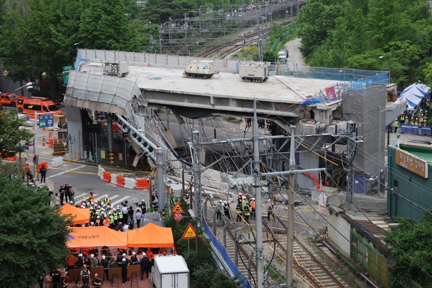 26日、崩落事故が発生したソウル西大門区（ソデムング）の西小門（ソソムン）高架車道撤去現場で、消防関係者らが事故収拾作業を行っている。聯合ニュース